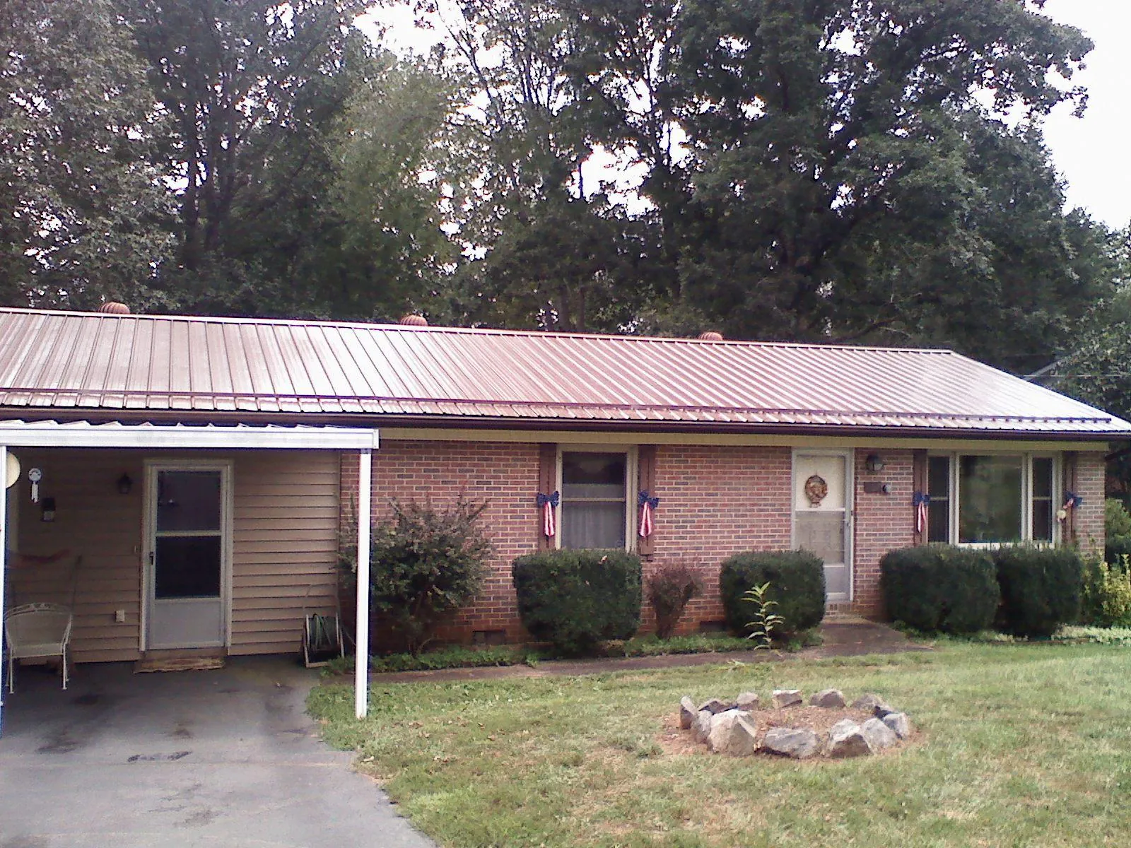 Bronze metal roof and carport on a brick ranch home — Roof Repair work by our crew in Sumas